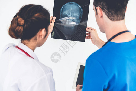 女医生在医院与另一位医生一起工作时查看患者头部受伤的X光片医疗保健人图片