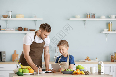 快乐的父亲和儿子在厨图片
