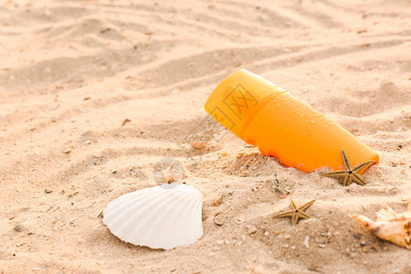沙滩上的一瓶防晒霜背景图片