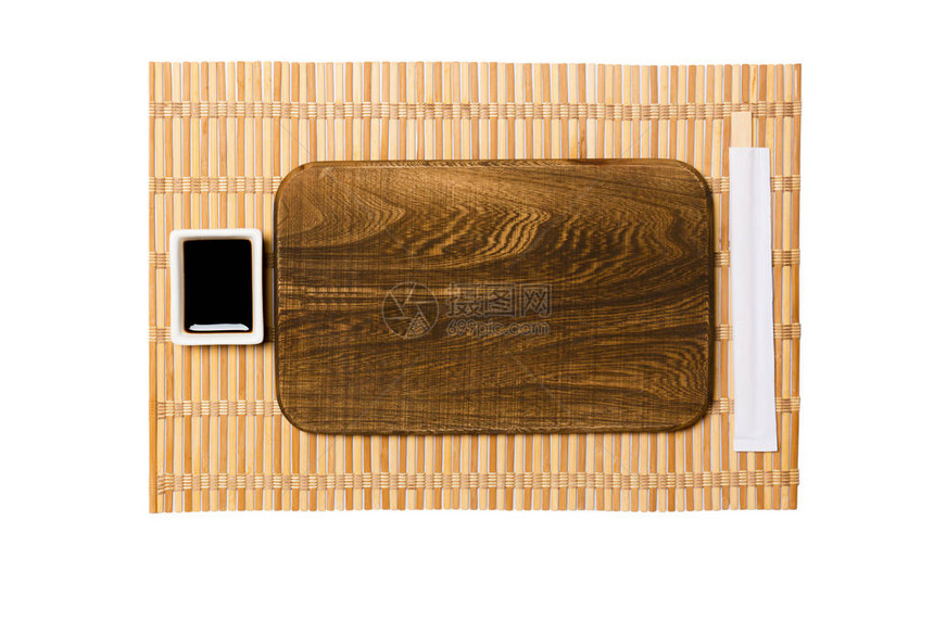 黄色竹席背景上带筷子的空长方形棕色木盘图片