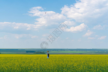 一个长头发的快乐女孩站在绿色田野的草地上图片