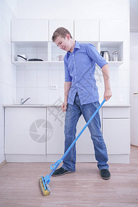 新时代好少年穿蓝牛仔裤的好少年男孩帮助他独自清扫公寓在白色房背景