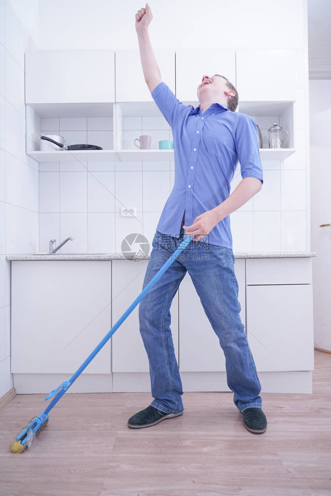 穿蓝牛仔裤的好少年男孩帮助他独自清扫公寓在白色房图片