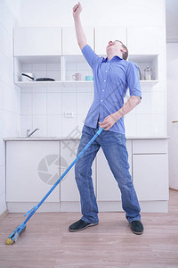 穿蓝牛仔裤的好少年男孩帮助他独自清扫公寓在白色房图片