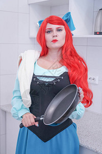 红头发的公主穿着蓝色连衣裙用毛巾洗锅图片