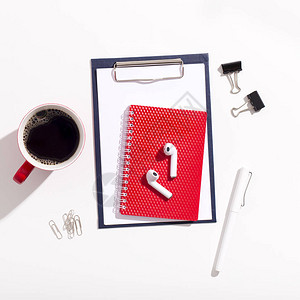 红杯咖啡耳机和笔记本放在白办公背景图片