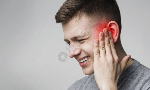 耳朵感染受苦的人摸着他发炎的图片