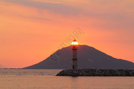 日落时的海景海岸上的灯塔图片