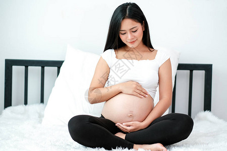 亚洲美丽的孕妇触摸她的肚子图片