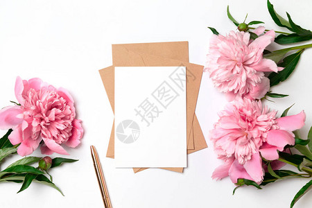 白色背景的婚礼邀请函手工信封粉红色花朵和绿色叶子图片