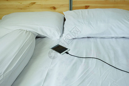 智能手机充电插在白床上睡觉充电的危险图片