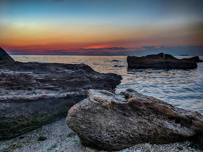 夏季日落时带石头的海线图片