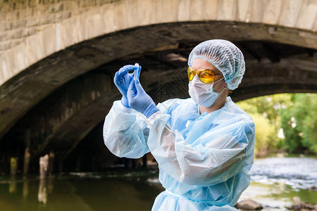 女生态学家或传染病专家用城市河流的水焦图片