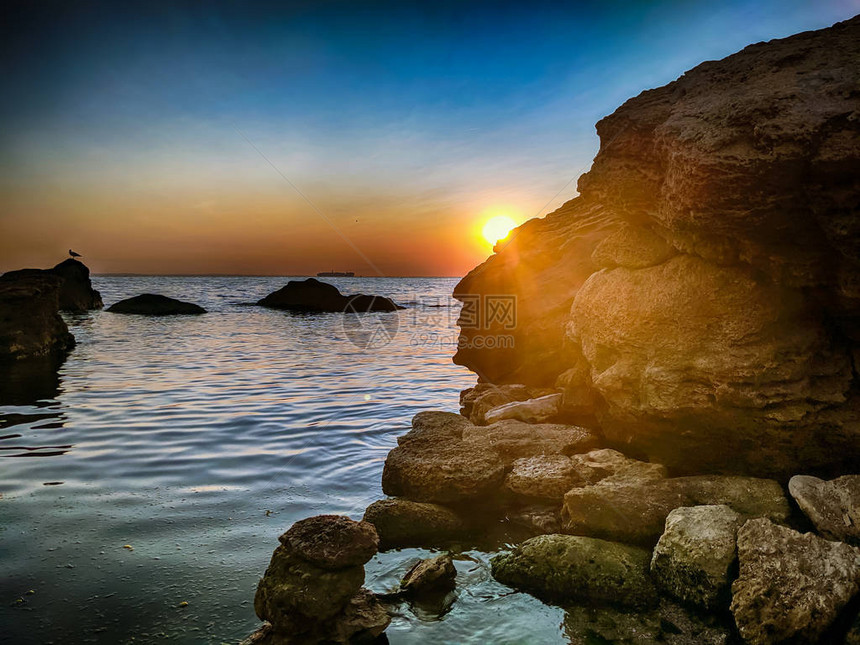 夏季日落时带石头的海线图片