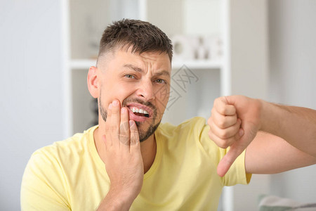 男子在家牙痛时大拇指朝下图片