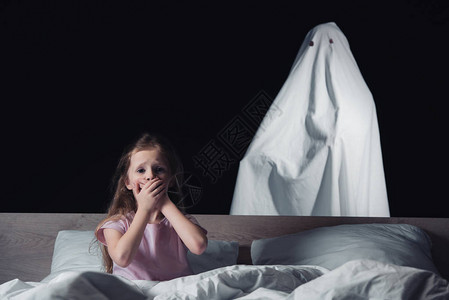 吓坏了的孩子坐在床上图片