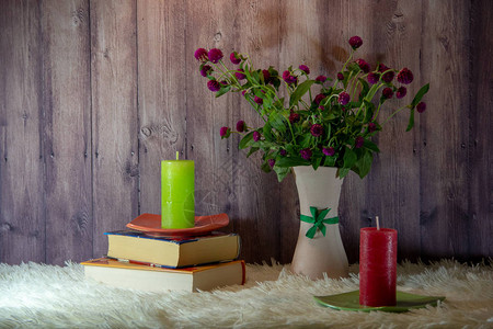 花瓶里的一束野花书籍蓬松的白色床罩上碟子上的两支蜡图片