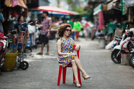 亚洲女人坐在街中间的椅子上图片