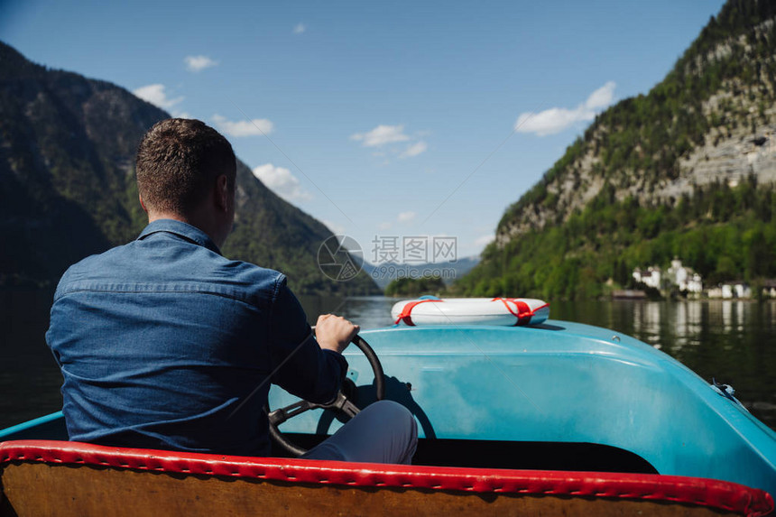 帅的年轻人控制着山湖上一艘机动艇图片