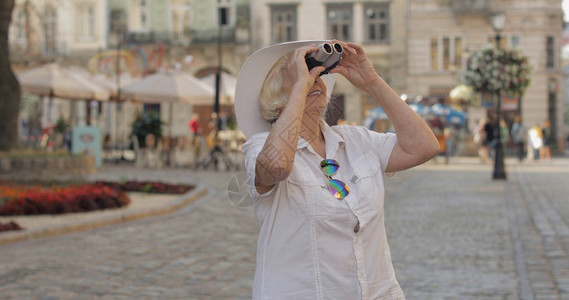 高级女旅游者探索城镇和看望远镜图片