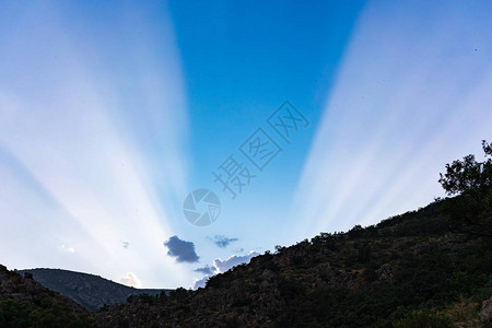 夕阳照在山上蓝天上的阳光图片