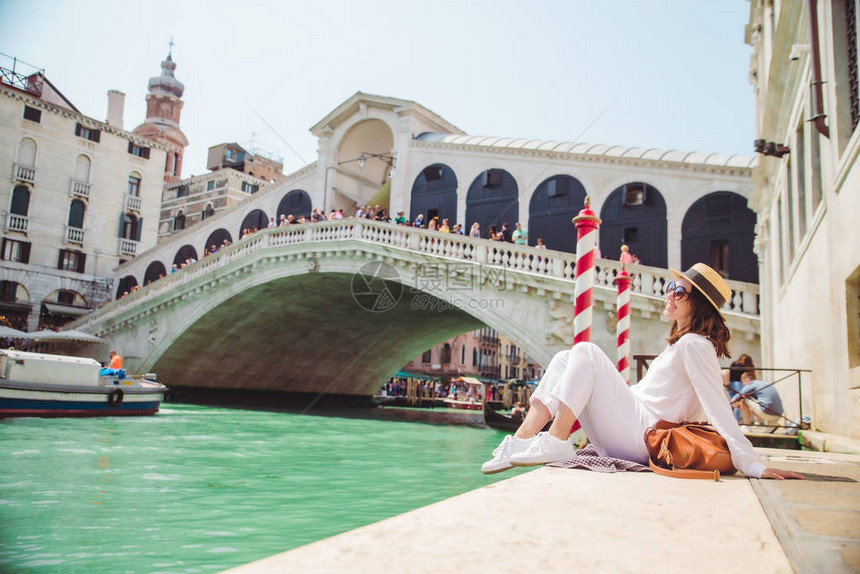 坐在Rialto桥附近的妇女在VeniceItaly看着大运河与Gondolas夏季图片