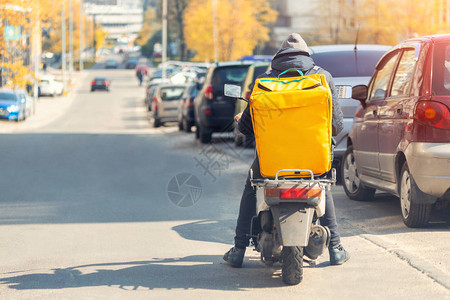 送食品的快递员和大黄背包骑摩托车图片