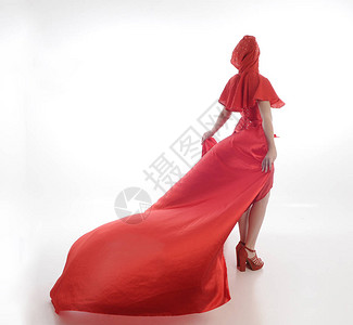 身穿红色骑钩斗篷和长丝袍的妇女全长肖像站在白工作室背景图片
