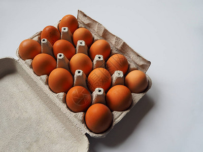 一组15个棕色新鲜生鸡蛋在白色背景的白箱蛋盒里紧图片