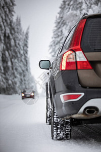 汽车在森林中白雪皑的冬季道路上行驶利用其四轮驱动图片