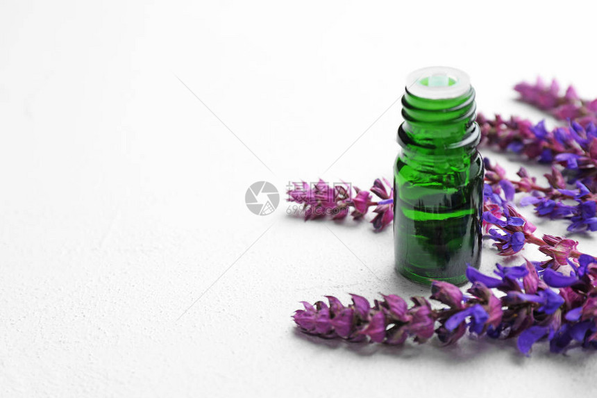 桌上的香精基本油和鲜花瓶图片