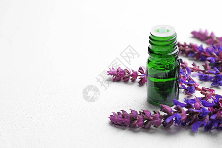 桌上的香精基本油和鲜花瓶背景图片