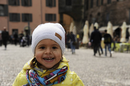 冬天在街上笑得可爱的小女孩肖像图片