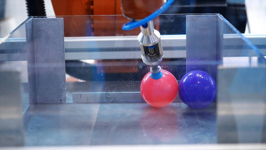 重新安置小塑料多彩姿的球机器手的特写镜头论坛展览上展示了不同的工图片