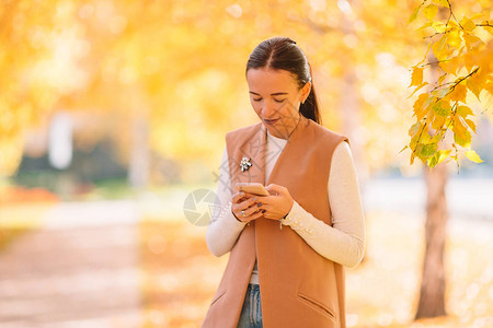 秋天公园里的美女发短信图片