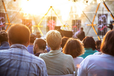 夏季后院公园的街头音乐会观众坐在舞台椅子上的背景图片