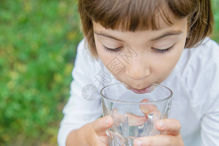 孩子从玻璃杯里喝水选择焦点图片