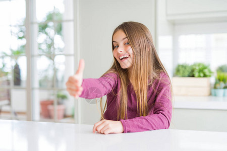 美丽的年轻女孩在白桌边微笑着亲切的握手作为问候和欢迎成功的业图片
