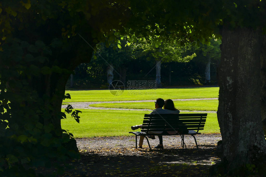 一对夫妇在斯德哥尔摩以北一小时车程的斯科克洛斯特城堡公园的长椅上图片