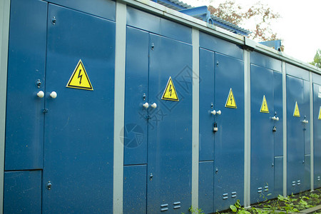 蓝色变压器箱变电站蓝色墙上带有注意标志的锁定电动金属图片