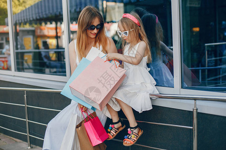夏天城市的漂亮女孩带购物袋的女士穿着时装的妈图片