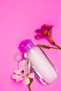 带有霓虹灯紫色花朵的护肤化妆品瓶产品用于清洁卸妆面部补品胶束水护肤品样机背景图片