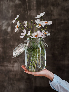 一束白花在一个玻璃罐子里图片