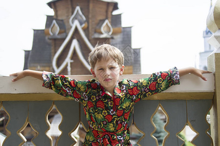 在木制建筑背景上身着俄罗斯民族服装的男孩图片