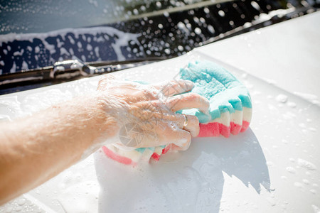手握海绵洗车脏车图片
