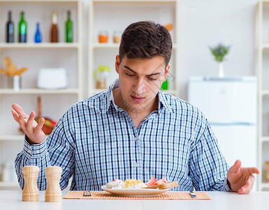 年轻丈夫在家吃不好吃的午餐时在家里吃没图片