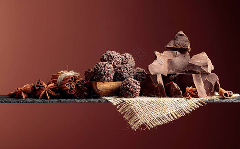 松露巧克力碎块巧克力和香料深色背景上的巧克力肉桂棒和茴图片