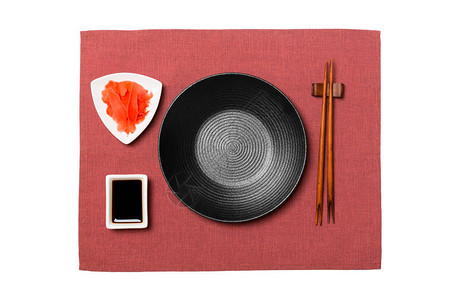 用筷子做寿司和酱油的空圆黑盘图片