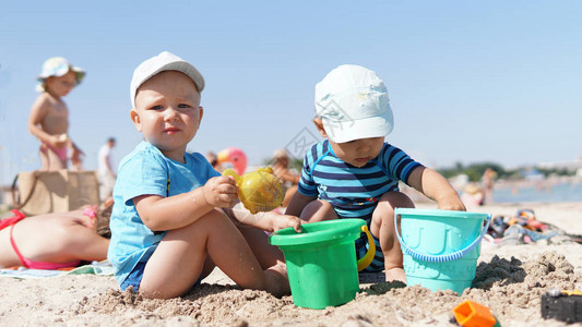两个小孩在海滩上玩沙子男孩图片