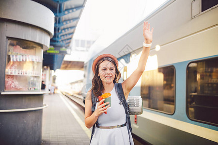 背包旅行者女人在火车站平台暑假旅游概念挥手图片